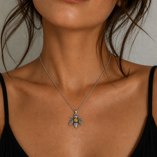 Necklace with a bee pendant worn by a model against a neutral background