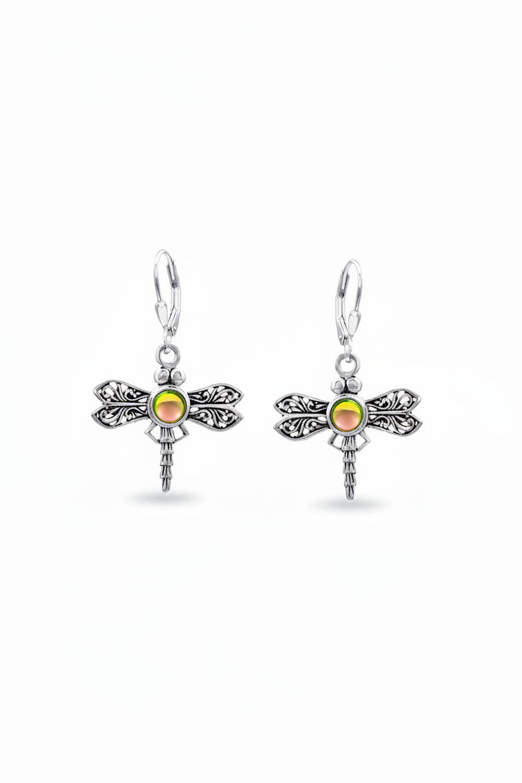 A pair of sterling silver dragonfly earrings with intricate details and a glowing crystal center.
