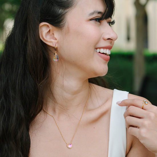 Fall in love with the Aurora - Heart Crystal Necklace, a stunning symbol of love and elegance. This beautiful necklace features a radiant heart-shaped crystal, surrounded by a delicate halo of smaller crystals that enhance its brilliance. Designed to capture and reflect light, this necklace creates a sparkling effect that adds a touch of glamour to any outfit.