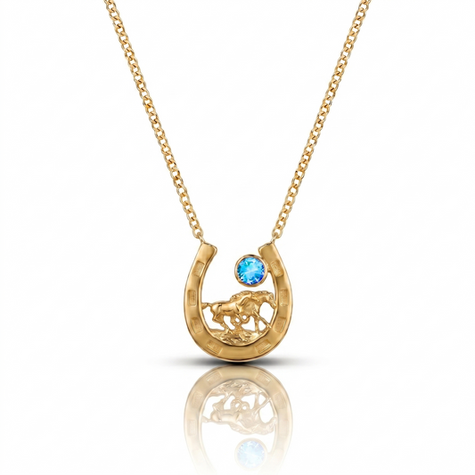 Gold necklace with a horseshoe pendant featuring a blue gemstone on a white background