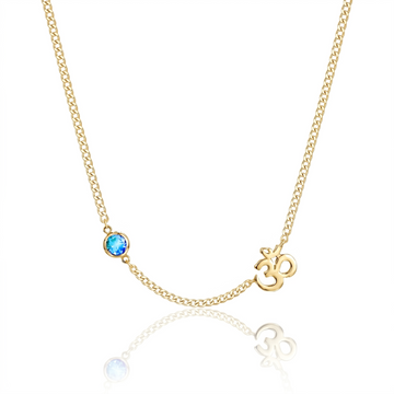 Gold necklace with a blue gemstone and 'OM' symbol on a white background