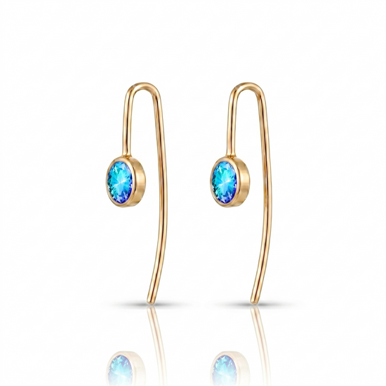 Gold earrings with blue gemstones on a white background