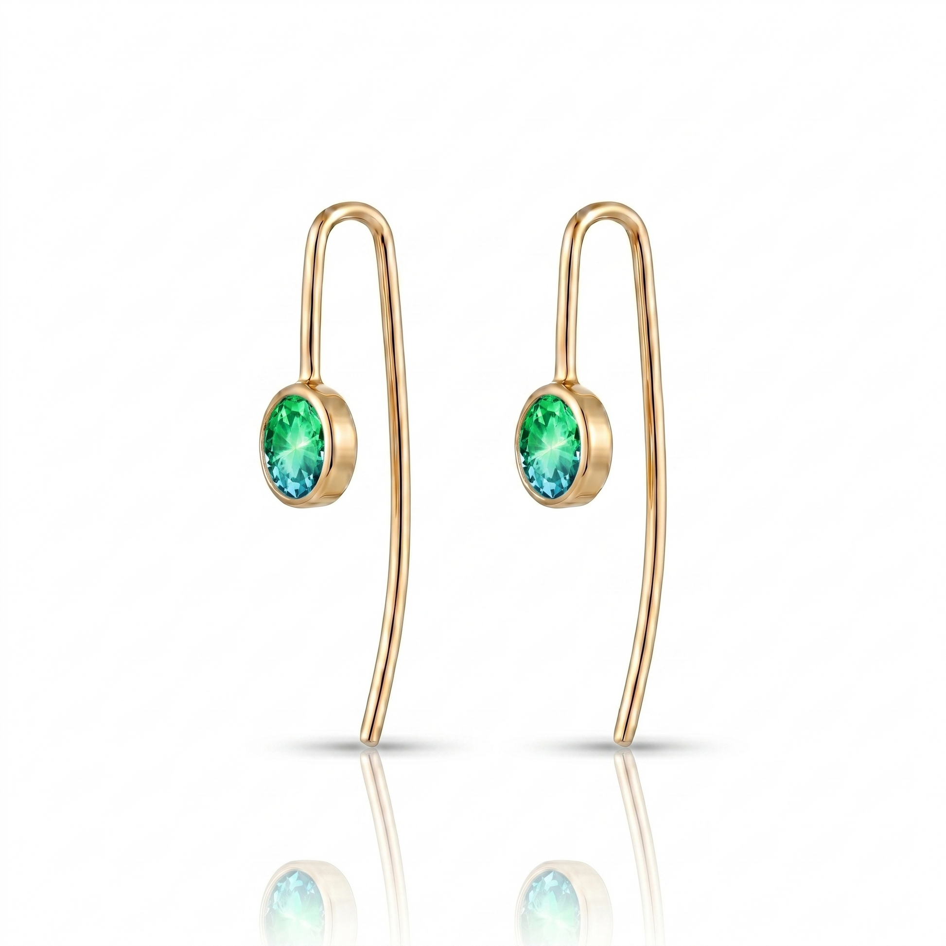 Gold earrings with green gemstones on a white background