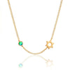 Gold necklace with a green gemstone and star-shaped pendant on a white background