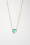 Heart-shaped opal pendant on a gold chain against a white background