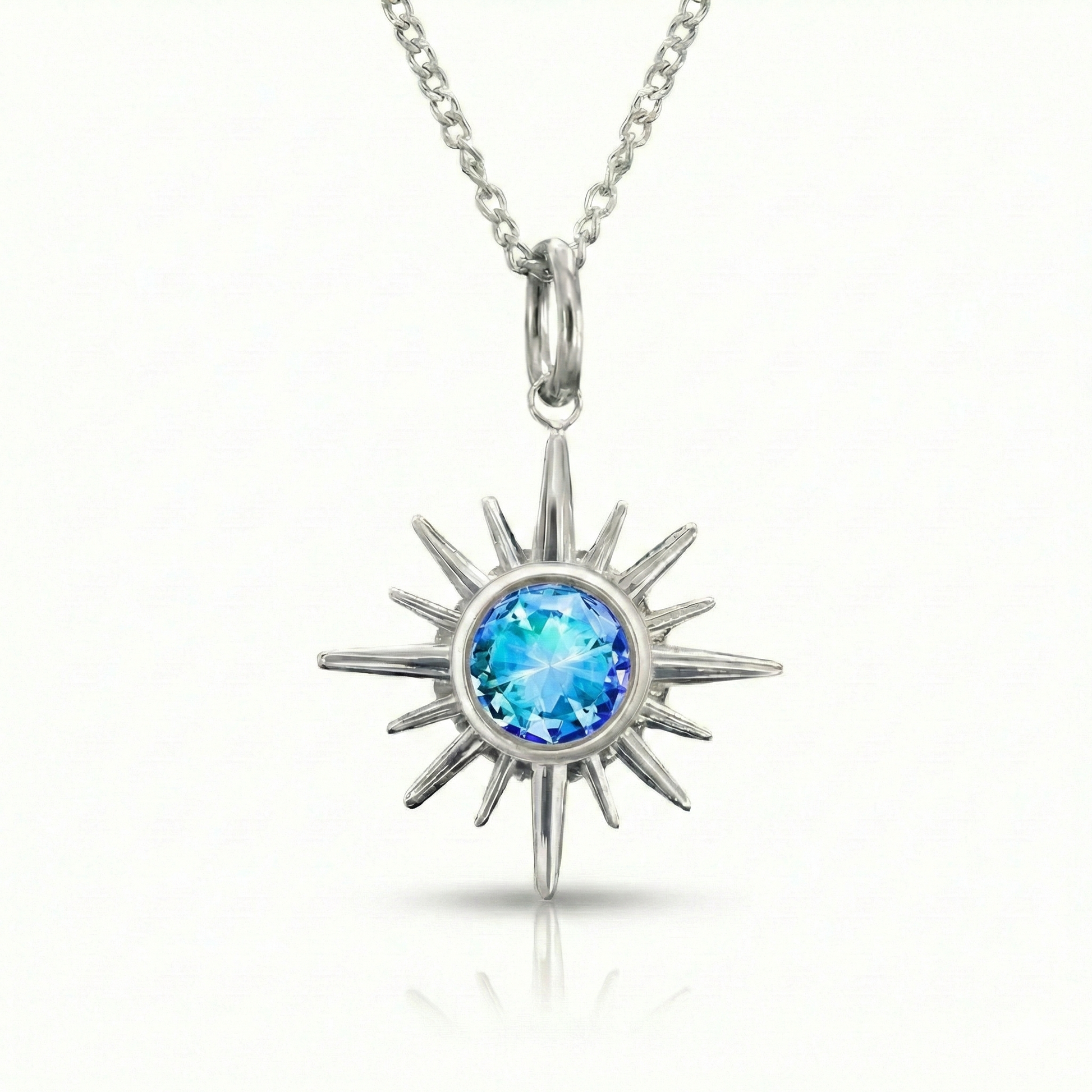 Silver sun-shaped pendant with a blue gemstone.