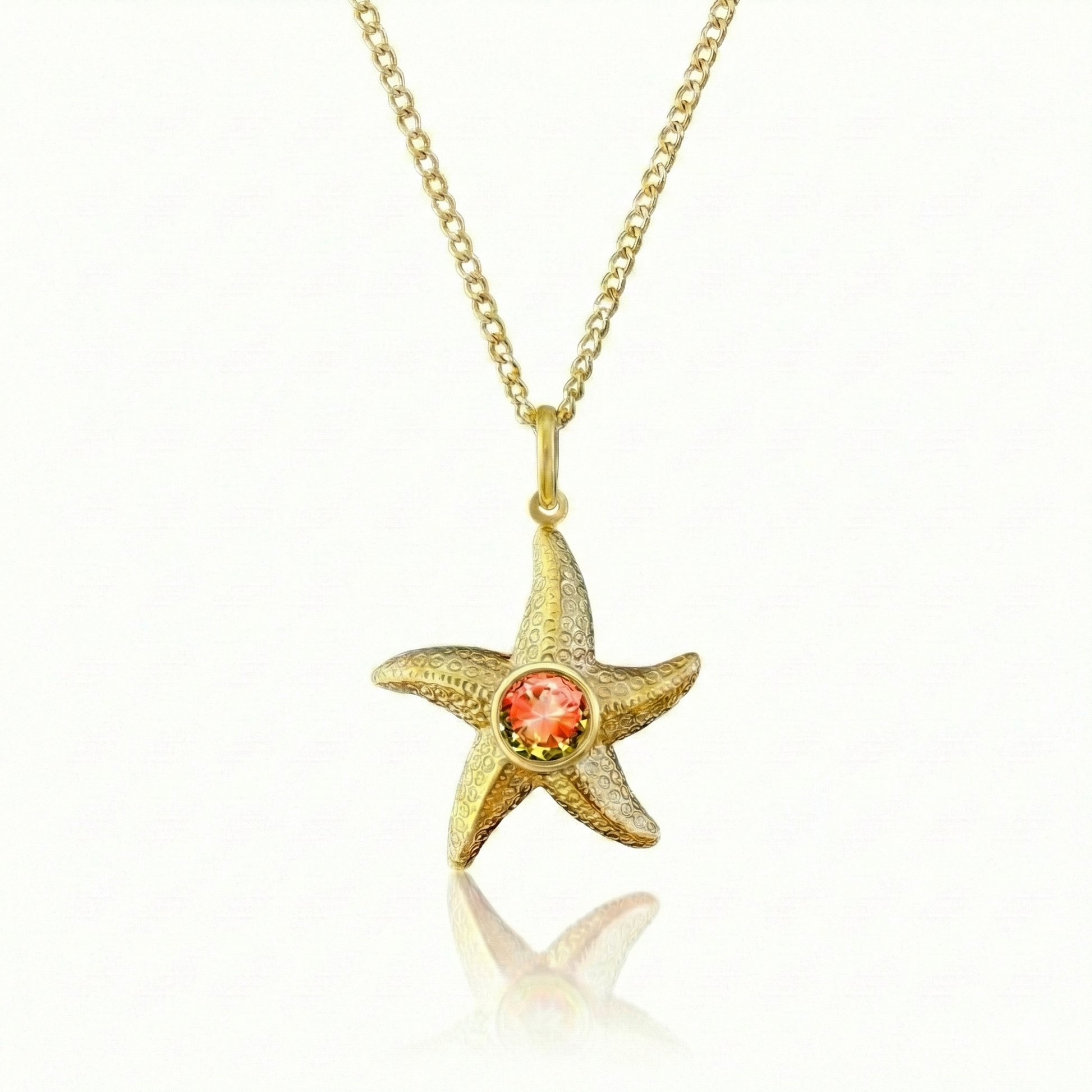 Gold starfish pendant with a red gemstone 