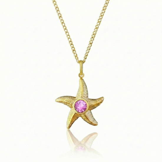 Gold starfish pendant with a pink gemstone on a gold chain