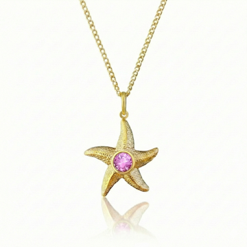 Gold starfish pendant with a pink gemstone on a gold chain