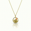 Gold necklace with a circular pendant featuring a mountain design.