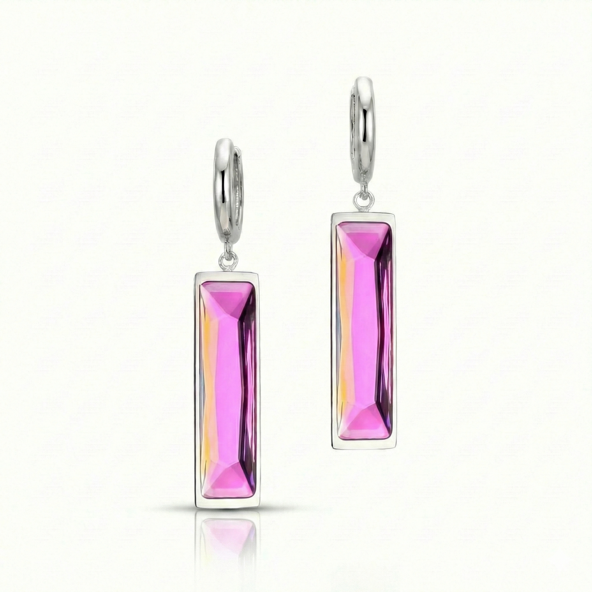 Silver earrings with pink gemstones on a white background