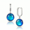 Pair of silver earrings with blue round stones on a white background
