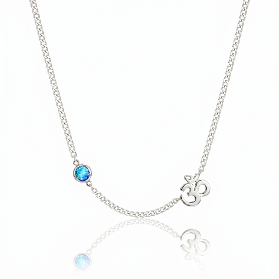 Om Necklace with a blue gemstone and a silver pendant on a white background