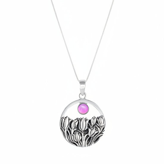 Necklace with a pendant featuring a pink gemstone and black and white design on a white background