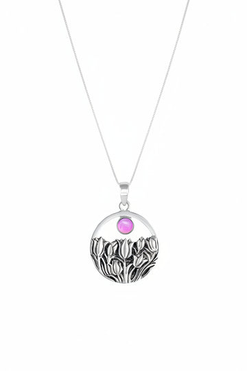 Necklace with a pendant featuring a pink gemstone and black and white design on a white background