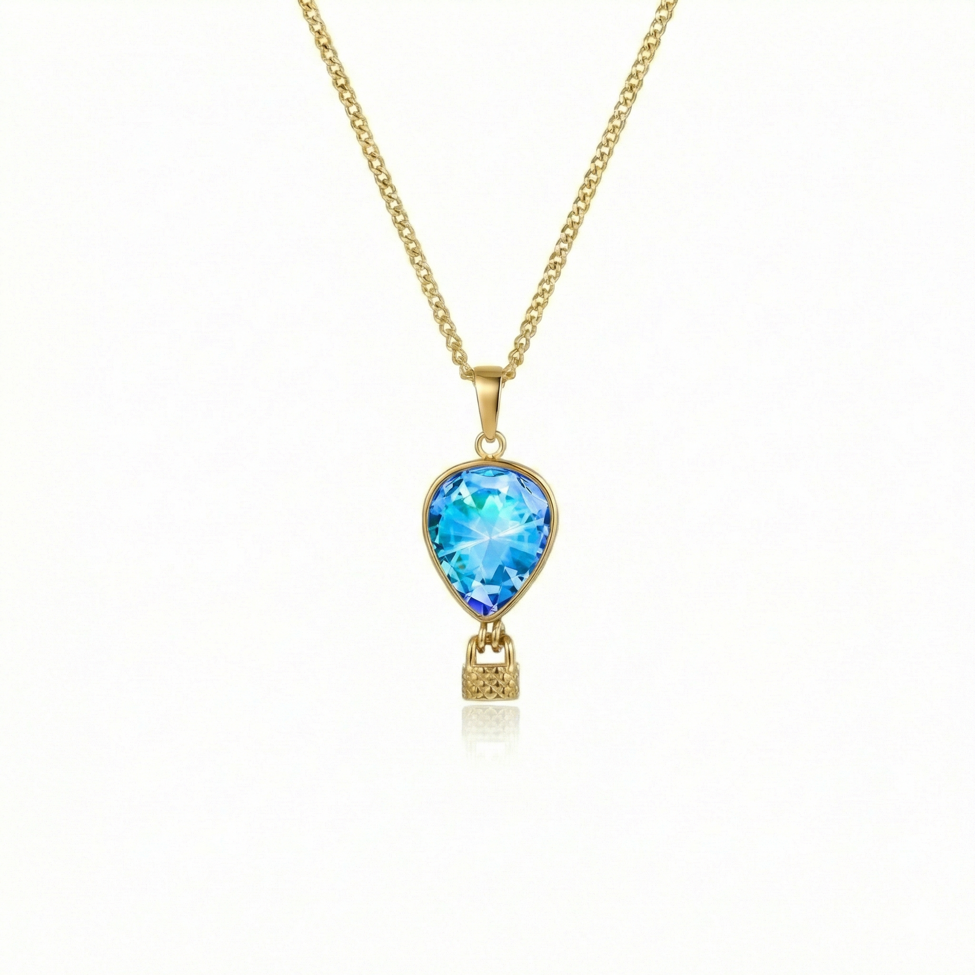 Gold necklace with a blue pendant featuring a delicate hot air balloon charm on a fine chain