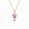 Gold necklace with a pink pendant featuring a delicate hot air balloon charm on a fine chain.