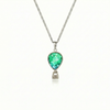 Silver necklace with a green pendant featuring a delicate hot air balloon charm on a fine chain.