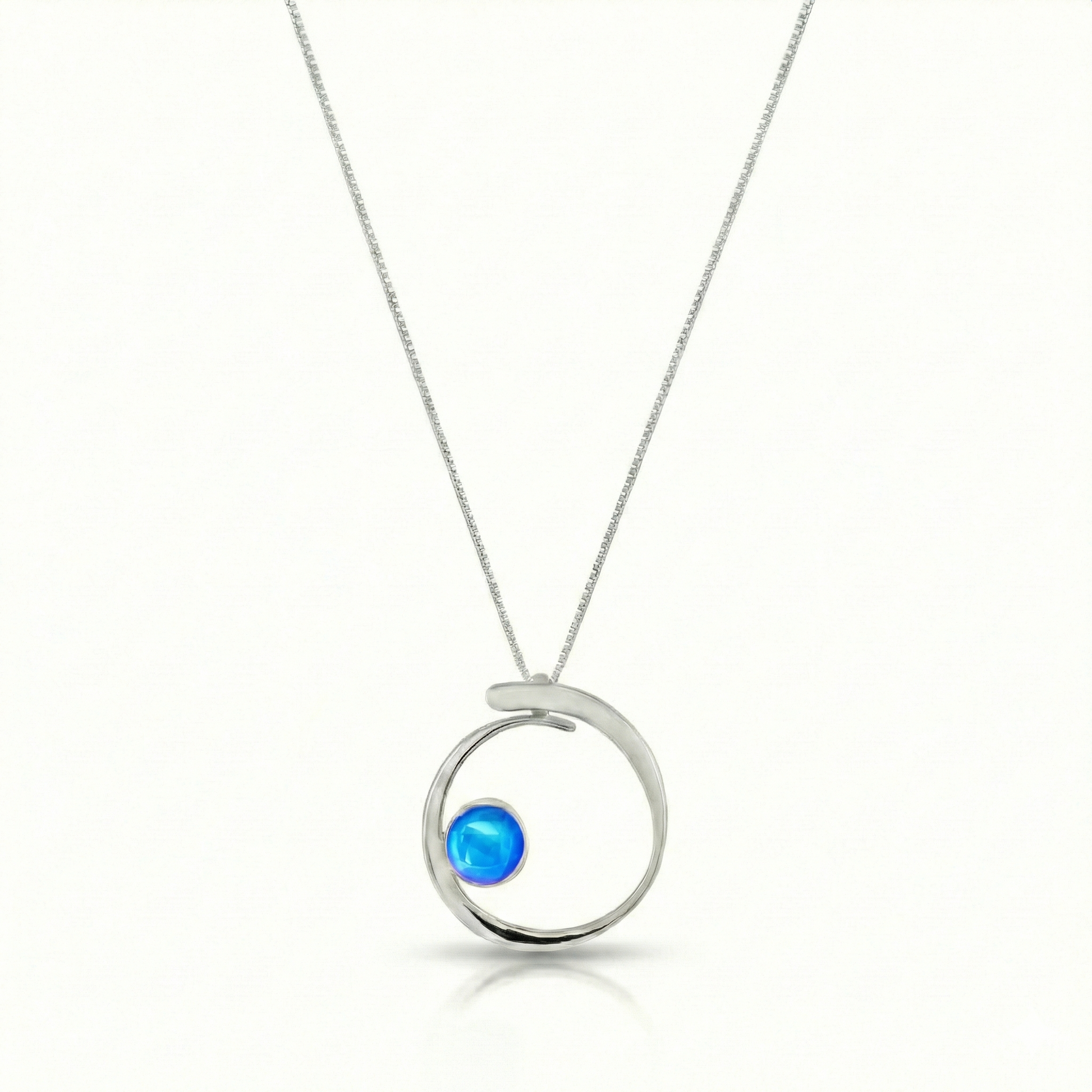 Barrel Pendant features a simple yet striking design that beautifully emulates the movement of a barrel within a wave. Crafted from high-quality sterling silver with polished blue crystal.