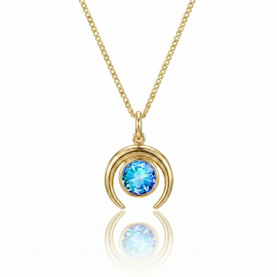 Gold crescent necklace with a blue gemstone pendant.
