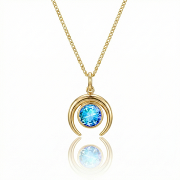 Gold crescent necklace with a blue gemstone pendant.