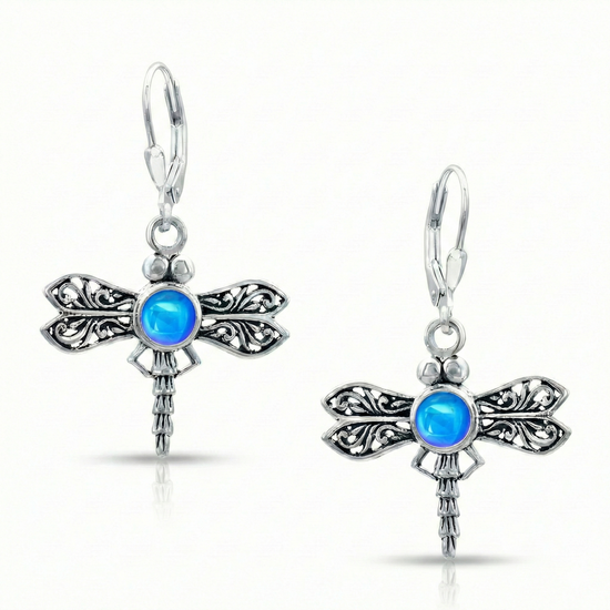 Sterling Silver Dragonfly Earrings feature a  polished blue glowing crystal delicately surrounded by intricate silver details in the wings and body of the dragonfly, creating a whimsical yet elegant look.