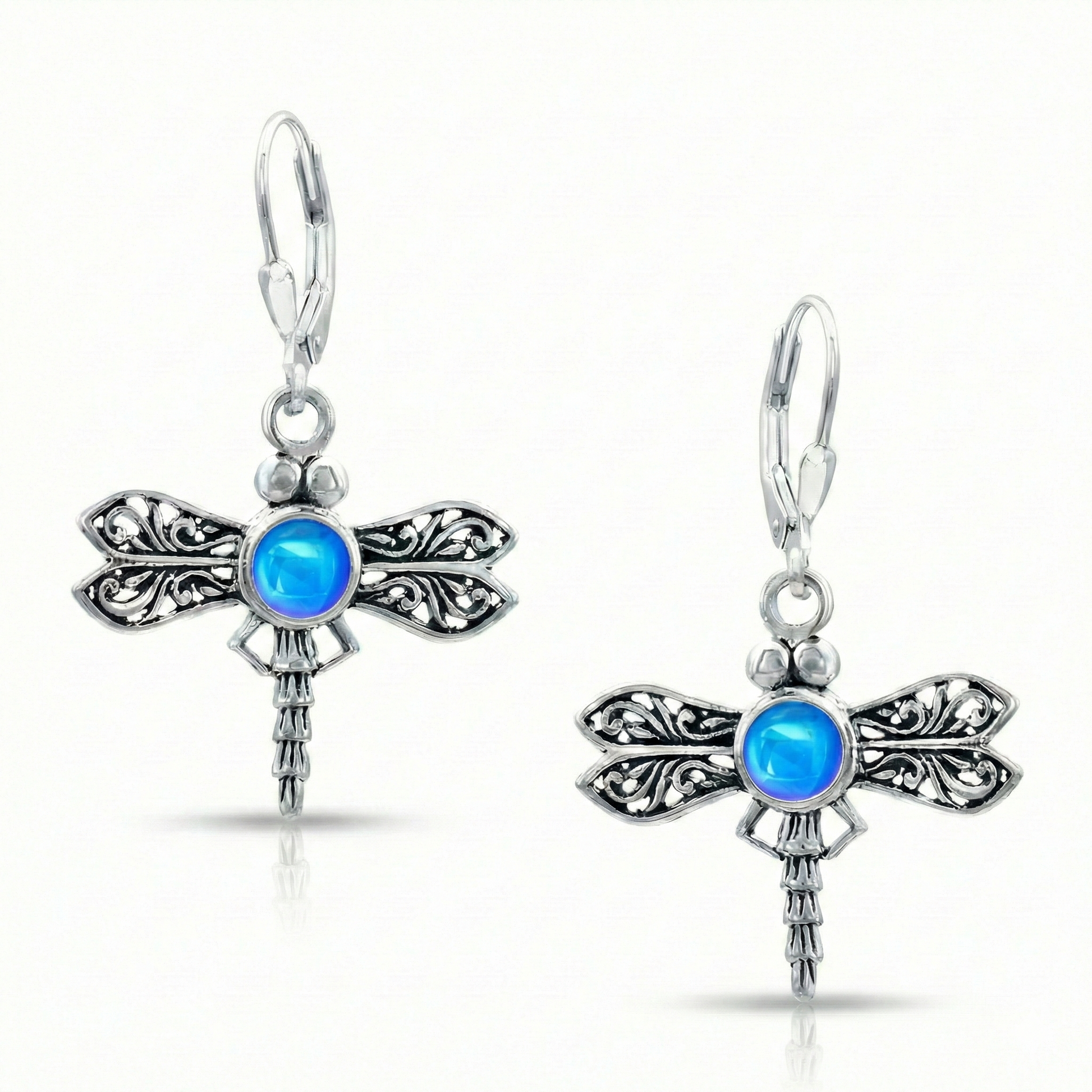 Sterling Silver Dragonfly Earrings feature a  polished blue glowing crystal delicately surrounded by intricate silver details in the wings and body of the dragonfly, creating a whimsical yet elegant look.