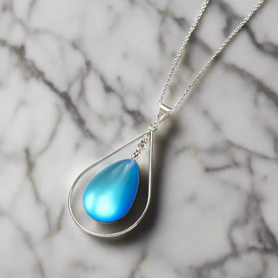 Drop with Loop Pendant is a classic design that elegantly radiates with polished blue pendant. It comes with an 18" .7mm sterling silver box chain, ensuring a complete and polished look.