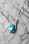 Drop with Loop Pendant is a classic design that elegantly radiates with polished blue pendant. It comes with an 18" .7mm sterling silver box chain, ensuring a complete and polished look.