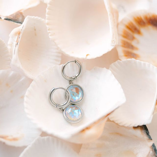  Perfectly sized with a 9mm circle, these earrings are crafted to add a subtle yet striking touch of sophistication to your everyday ensemble. Inspired by the celestial beauty of an eclipse, the minimalist design highlights a radiant crystal that catches the light with every move.