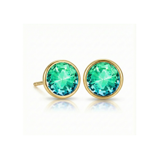 Gold earrings with green gemstones on a white background