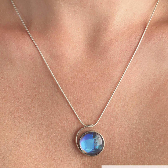 Large Wave Pendant, where it represents the "O" of Ocean Beach, while the surrounding silver symbolizes the "B." Crafted with .925 sterling silver components, the pendant comes with a 1mm sterling silver snake chain, 18" long with a polished blue stone.