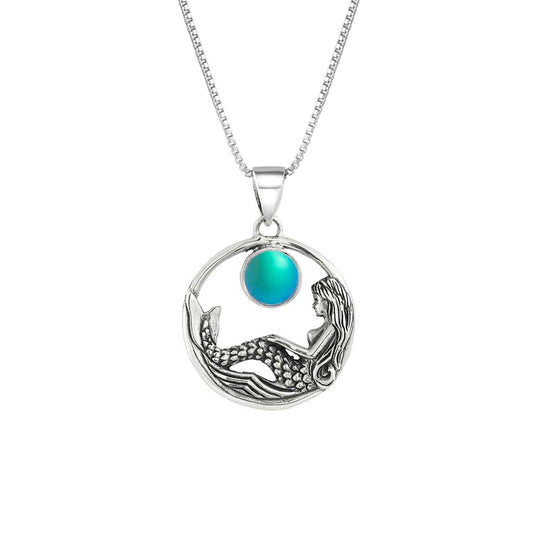 Mermaid Pendant features a beautiful mermaid sitting gracefully beneath a stunning 9mm glowing, frosted aqua crystal. The pendant comes with an 18" sterling silver .7mm box chain included.