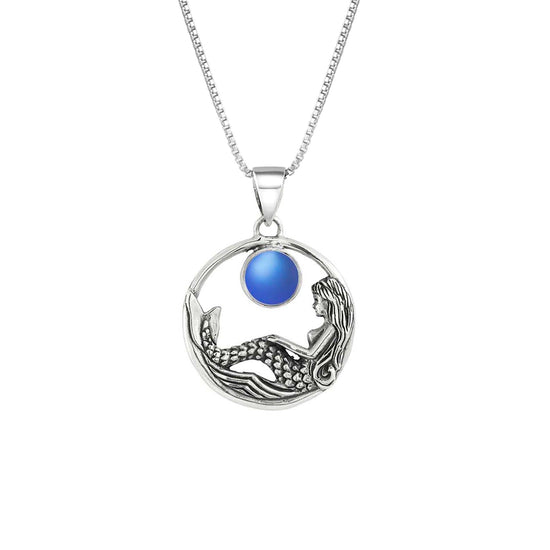 Mermaid Pendant features a beautiful mermaid sitting gracefully beneath a stunning 9mm glowing, frosted blue crystal. The pendant comes with an 18" sterling silver .7mm box chain included.