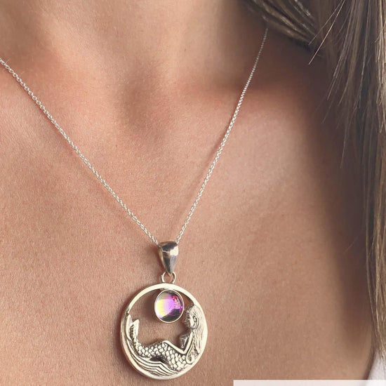 Mermaid Pendant features a beautiful mermaid sitting gracefully beneath a stunning 9mm glowing, polished pink crystal. The pendant comes with an 18" sterling silver .7mm box chain included.