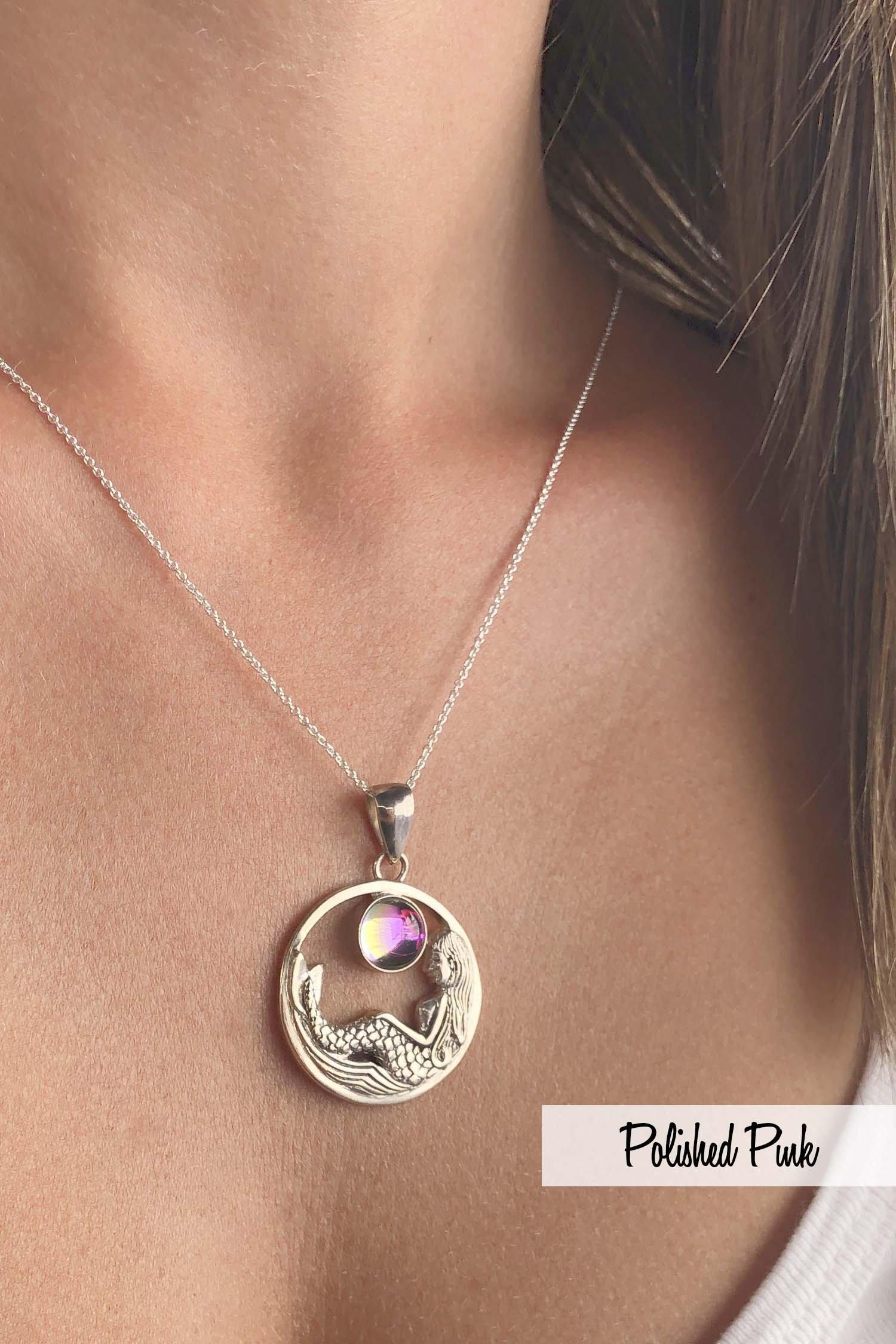 Mermaid Pendant features a beautiful mermaid sitting gracefully beneath a stunning 9mm glowing, polished pink crystal. The pendant comes with an 18" sterling silver .7mm box chain included.