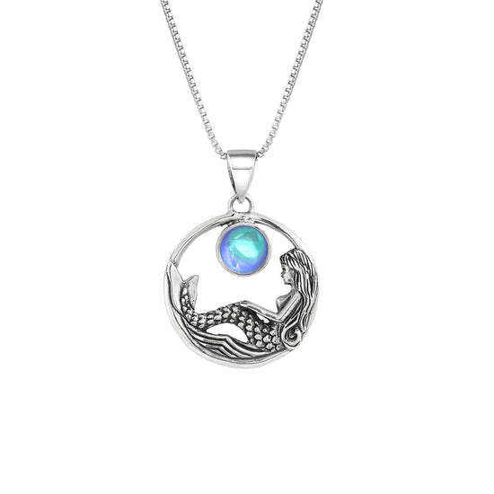 Mermaid Pendant features a beautiful mermaid sitting gracefully beneath a stunning 9mm glowing, polished aqua crystal. The pendant comes with an 18" sterling silver .7mm box chain included.