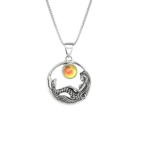 Mermaid Pendant features a beautiful mermaid sitting gracefully beneath a stunning 9mm glowing, polished fire crystal. The pendant comes with an 18" sterling silver .7mm box chain included.