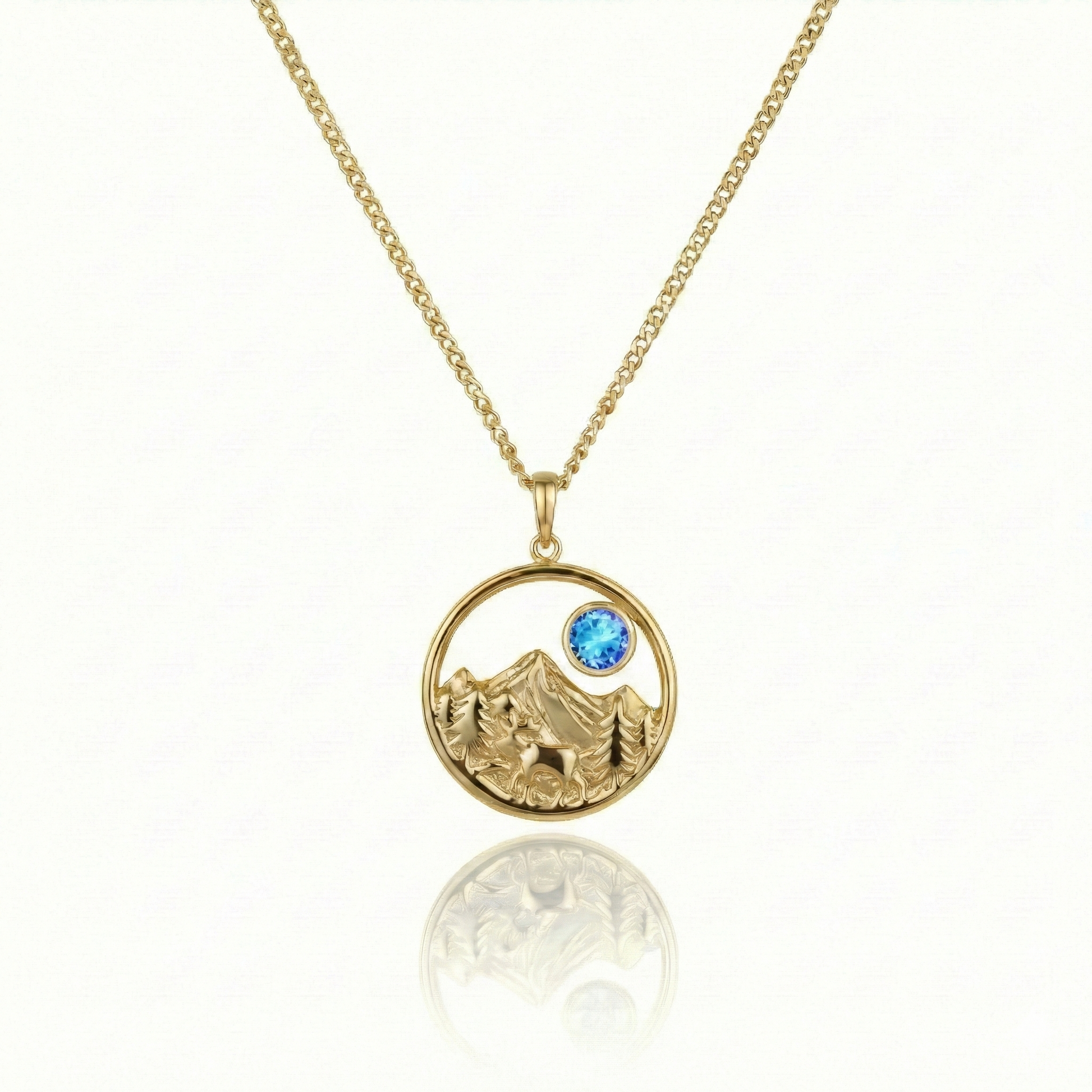 Gold necklace with a moose, mountain, and blue gem pendant.