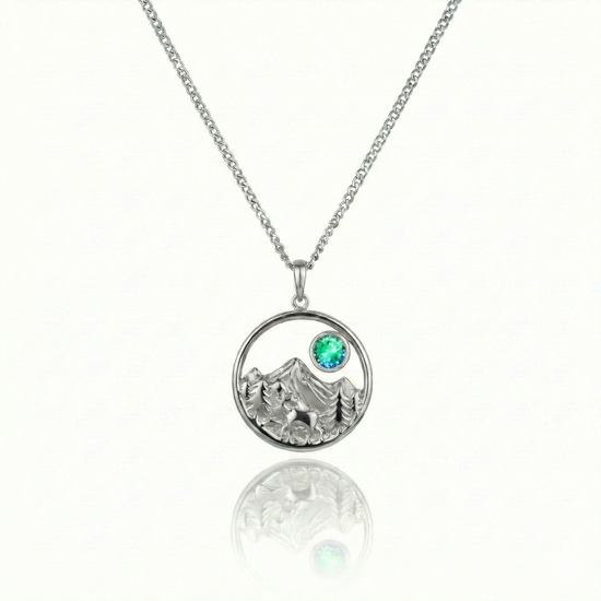 Silver necklace with a moose, mountain, and green gem pendant.