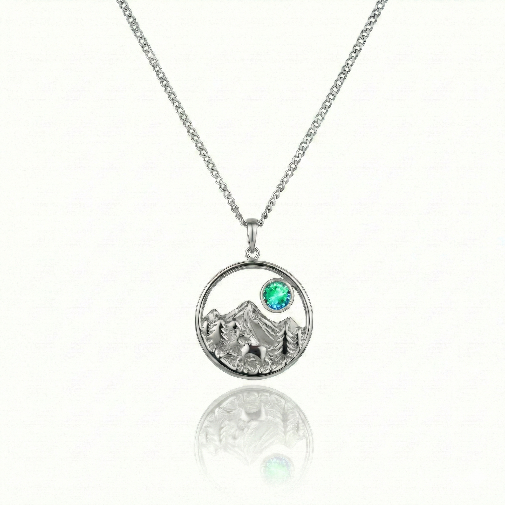 Silver necklace with a moose, mountain, and green gem pendant.
