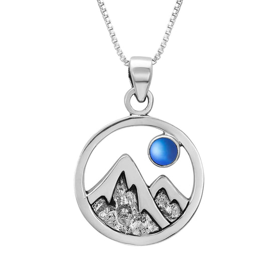 Mountain Pendant featuring a beautiful depiction of mountains under the moon or sun, this pendant captures the serene beauty of nature. The frosted blue pendant includes an 18" sterling silver .7mm box chain.