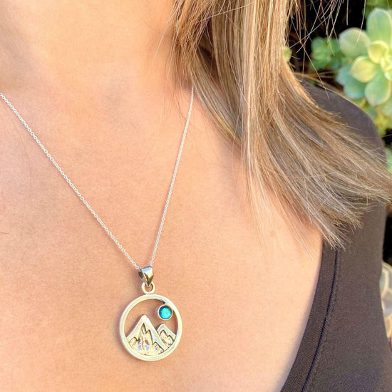 Mountain Pendant featuring a beautiful depiction of mountains under the moon or sun, this pendant captures the serene beauty of nature. The polished green pendant includes an 18" sterling silver .7mm box chain.