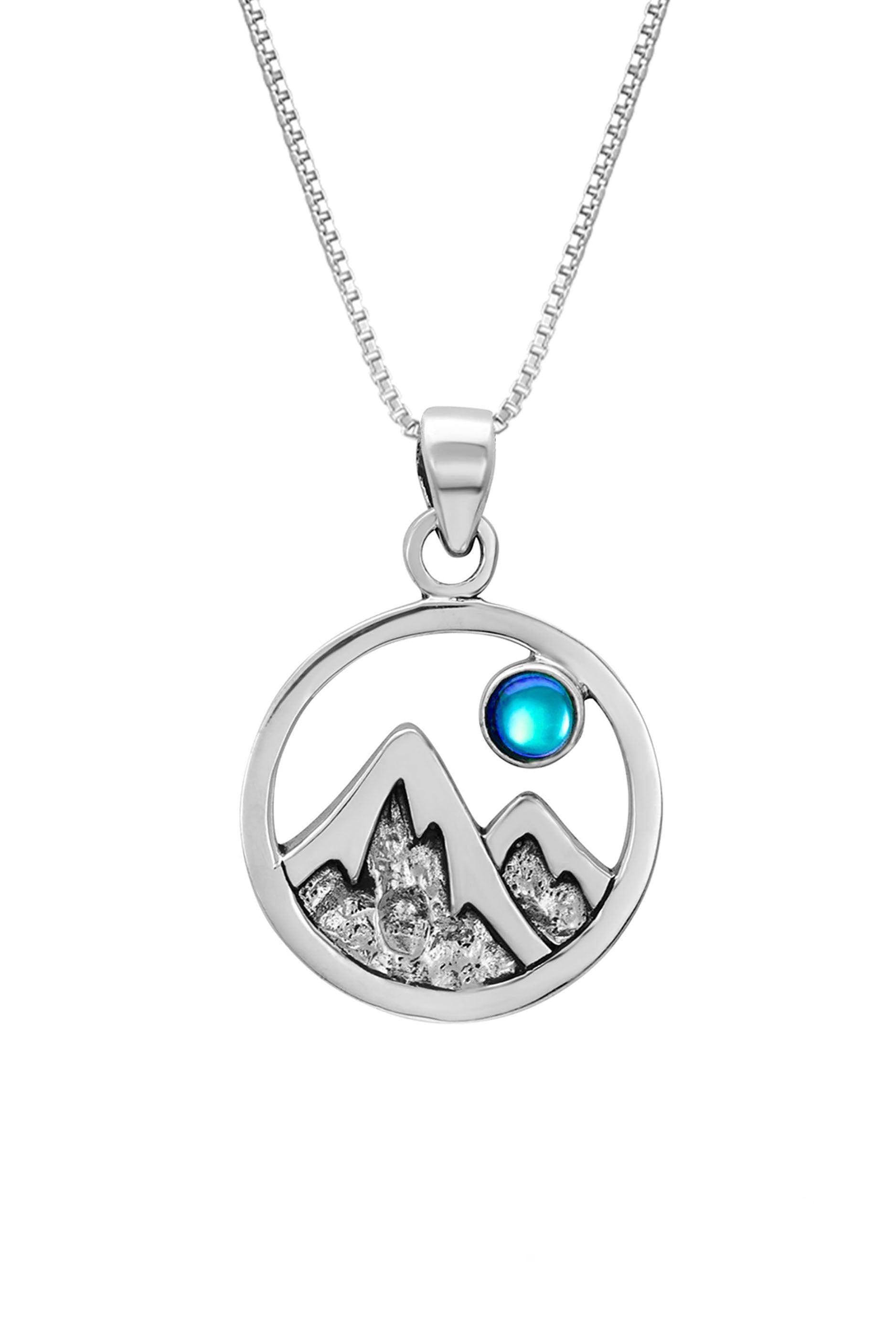 Mountain Pendant featuring a beautiful depiction of mountains under the moon or sun, this pendant captures the serene beauty of nature. The polished blue pendant includes an 18" sterling silver .7mm box chain.