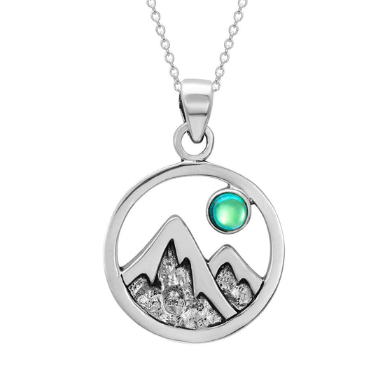 Mountain Pendant featuring a beautiful depiction of mountains under the moon or sun, this pendant captures the serene beauty of nature. The polished green pendant includes an 18" sterling silver .7mm box chain.
