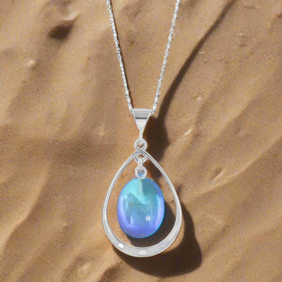 Oval with Loop Pendant handmade pendant pairs beautifully with any outfit, and you’ll love how the polished blue crystal oval shines with an iridescent glow of color from within. The pendant comes with an 18" sterling silver .7mm box chain included.