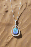 Oval with Loop Pendant handmade pendant pairs beautifully with any outfit, and you’ll love how the polished blue crystal oval shines with an iridescent glow of color from within. The pendant comes with an 18" sterling silver .7mm box chain included.