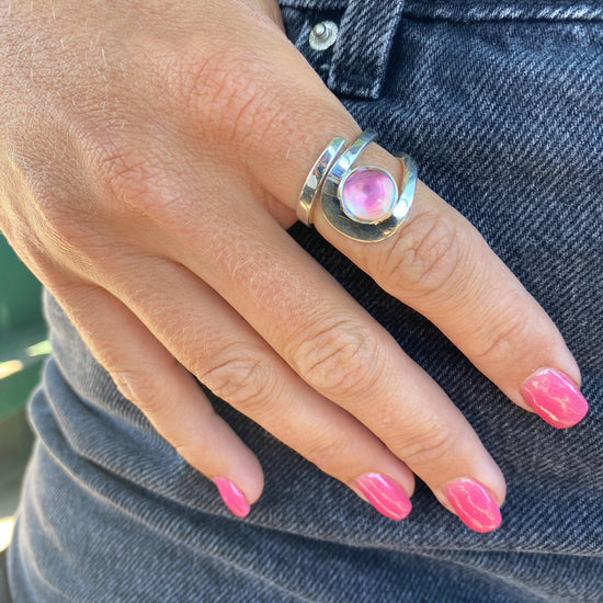 Raima Ring features a design that is not symmetrical, yet beautifully balanced. Crafted from sturdy sterling silver with polished pink stone, this ring is adjustable, allowing you to customize the fit starting at size 7.5.