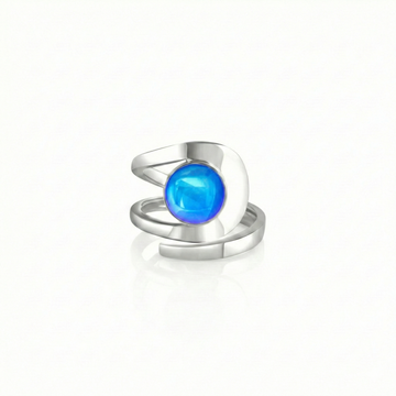 Raima Ring features a design that is not symmetrical, yet beautifully balanced. Its airy and light aesthetic brilliantly showcases the sparkling, polished blue crystal at its center. Crafted from sturdy sterling silver, this ring is adjustable, allowing you to customize the fit starting at size 7.5.
