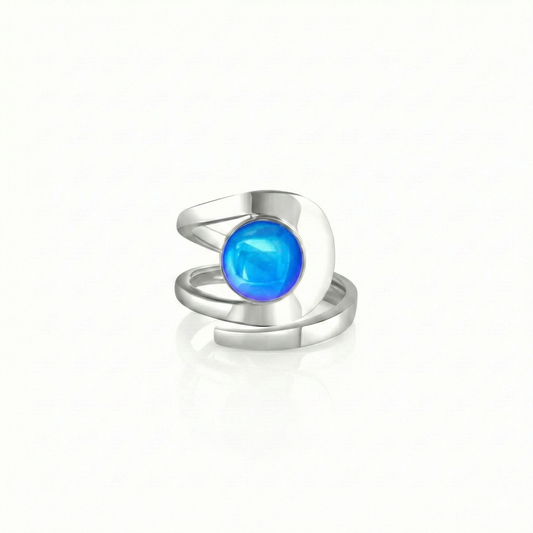 Raima Ring features a design that is not symmetrical, yet beautifully balanced. Its airy and light aesthetic brilliantly showcases the sparkling, polished blue crystal at its center. Crafted from sturdy sterling silver, this ring is adjustable, allowing you to customize the fit starting at size 7.5.